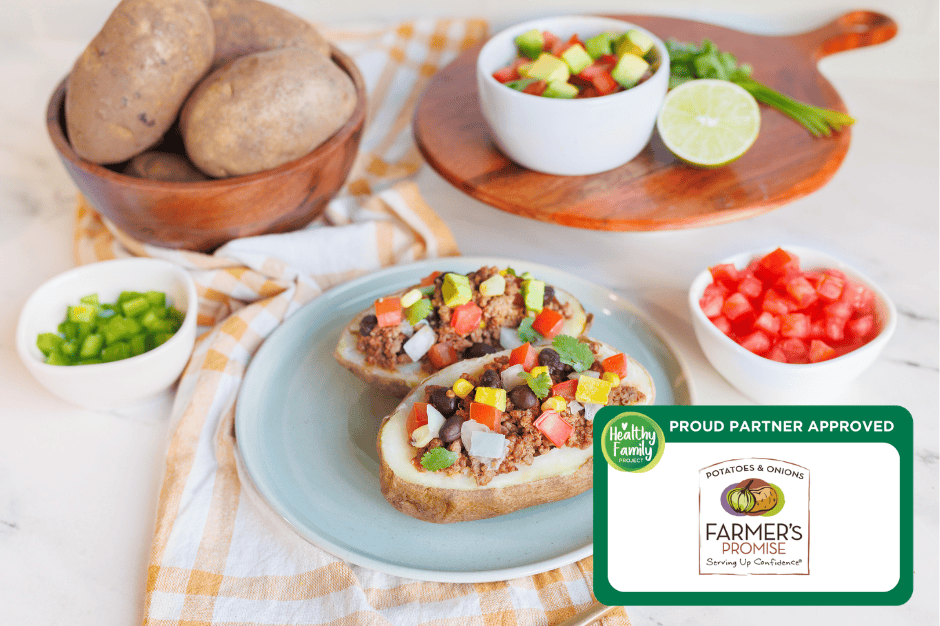 Taco Baked Potatoes Fiesta taco baked potatoes topped with seasoned ground meat, black beans, corn, avocado, and fresh vegetables, served with bowls of chopped ingredients.
