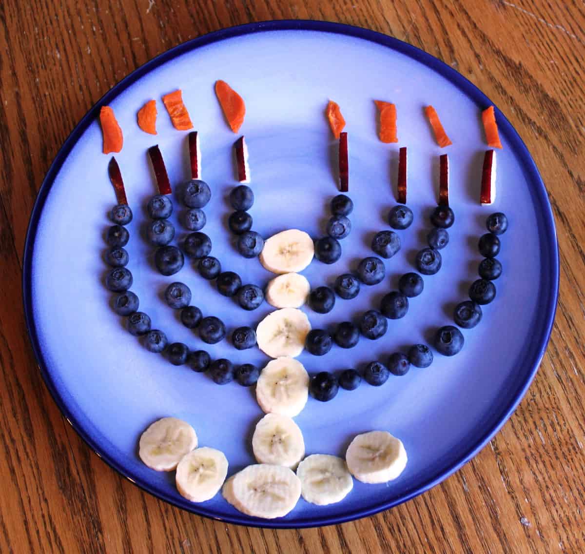 fruit menorah on blue plate on table 