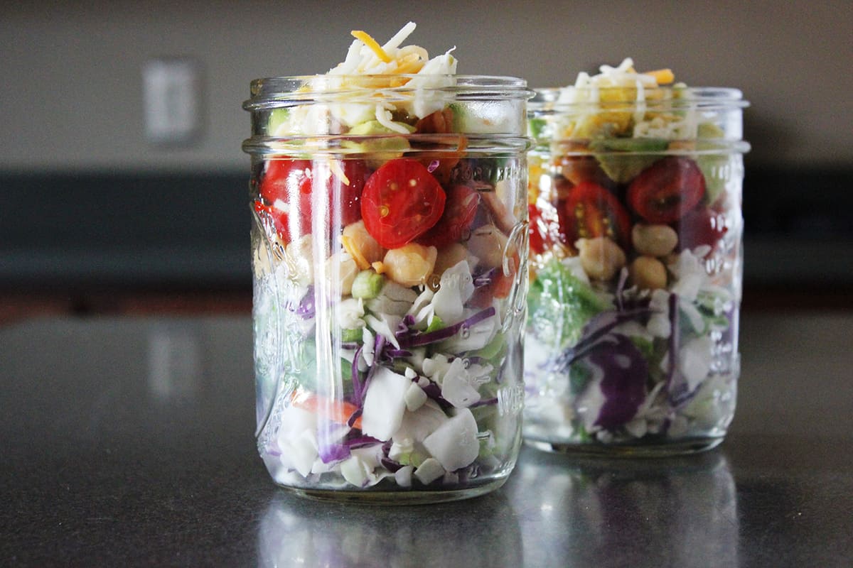 Two mason jars salad on counter