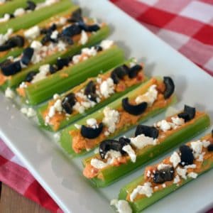 Greek Stuffed Celery - This easy celery recipe is stuffed with hummus and topped with crumbled feta cheese and chopped olives. Add a little more flair with chopped tomatoes, peppers or cucumbers. So easy, even kids can make these themselves!