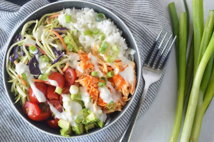 Buffalo chicken rice bowl on striped napkin