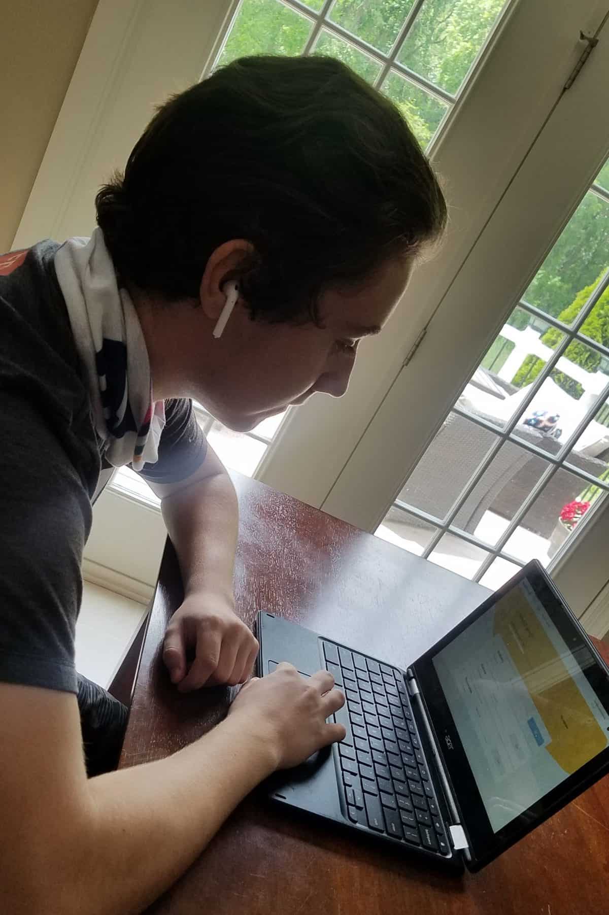 Boy engaged in virtual learning on a laptop, smiling