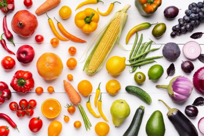 Various fruit and vegetables on white wood background