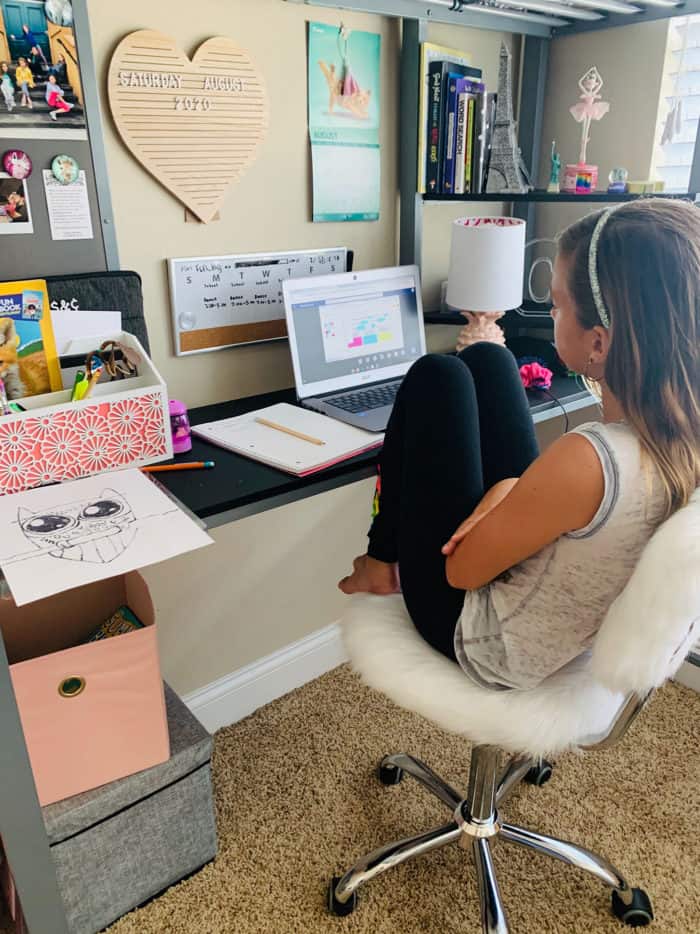 Girl sitting at desk with laptop open