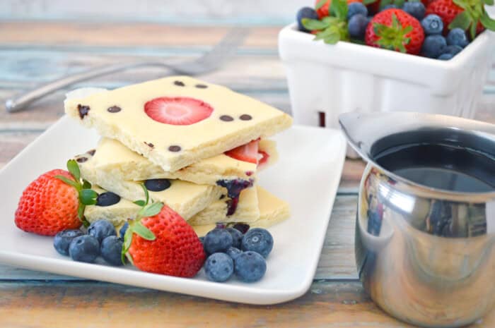 Sheet Pan Pancakes with berries and syrup.