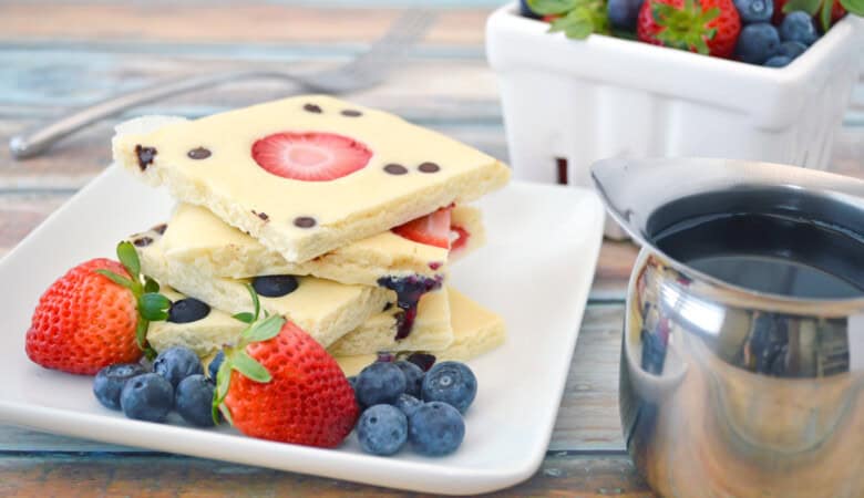 Sheet Pan Pancakes with berries and syrup.