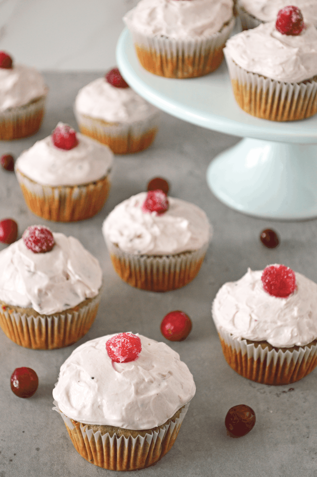 Cranberry cupcakes scattered on countertop.