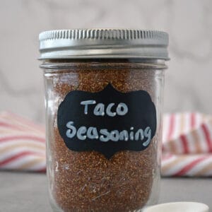 Mason jar of taco seasoning with measuring spoon.