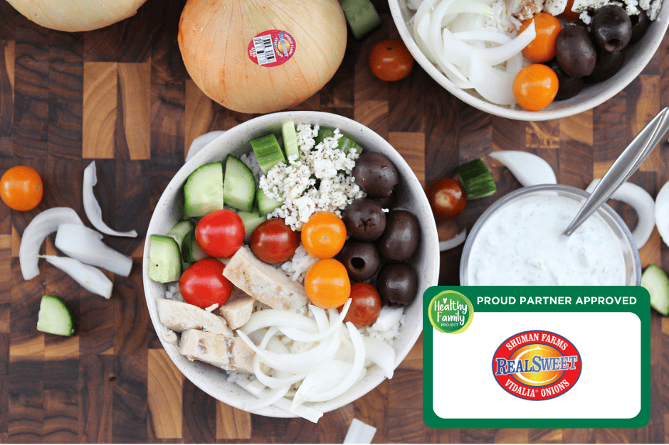 Greek Chicken Rice Bowls Healthy Mediterranean chicken rice bowl with cucumbers, tomatoes, olives, feta, and sweet Vidalia onions, served with creamy dressing.