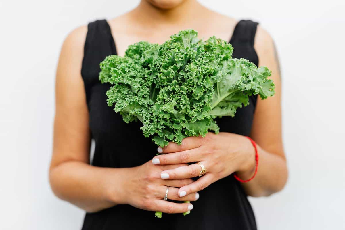 Turkey and Kale Quinoa Stuffed Peppers - Woman Holding Bunch of Kale