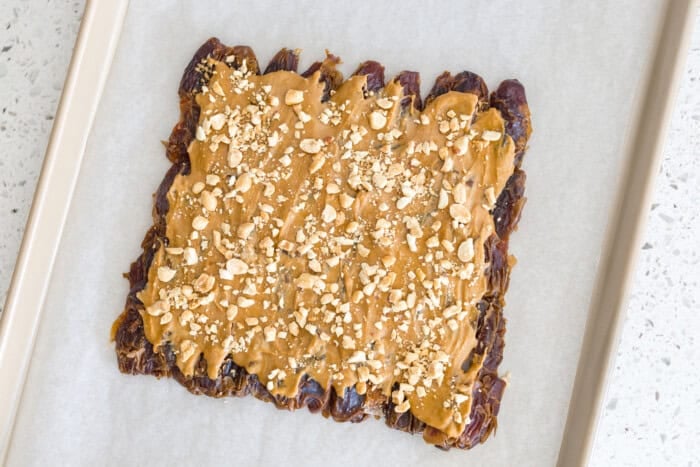 Date Bark preparation sheet with peanut butter and peanuts