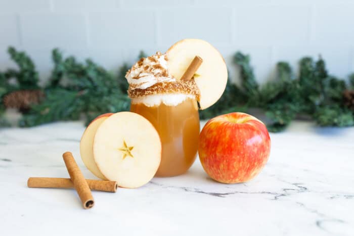 Apple cider mocktail drink with apples, and cinnamon