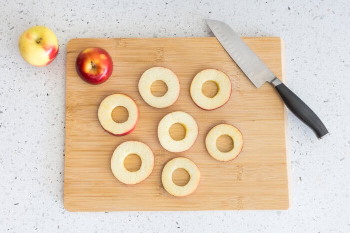 Apples and slices on a chopping board.