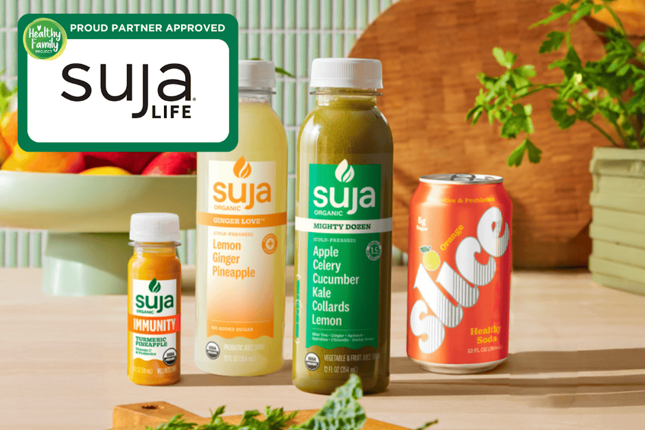 Suja organic cold-pressed juices including lemon ginger pineapple and green juice, alongside Slice healthy soda, displayed with fresh fruits and vegetables.