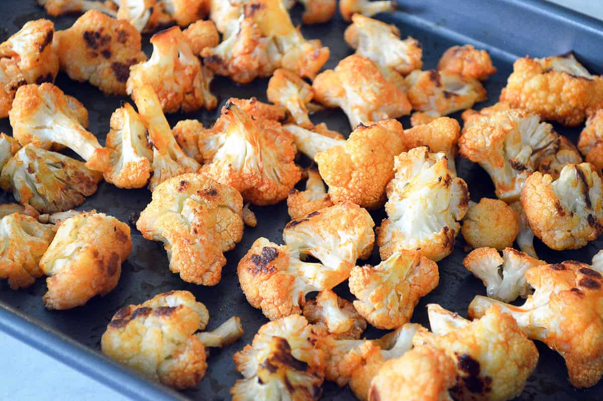 Buffalo Lettuce Wraps Roasted buffalo cauliflower florets on a baking sheet, crispy and seasoned for a healthy vegetarian recipe.
