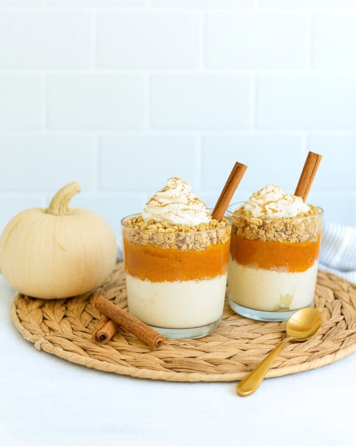 Pumpkin parfait made with protein yogurt, pumpkin puree and granola layered in a glass for a light Thanksgiving dessert.