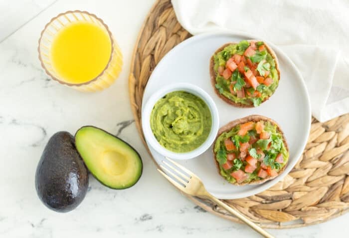 Easy avocado breakfast ideas with guacamole English muffins topped with tomato and cilantro