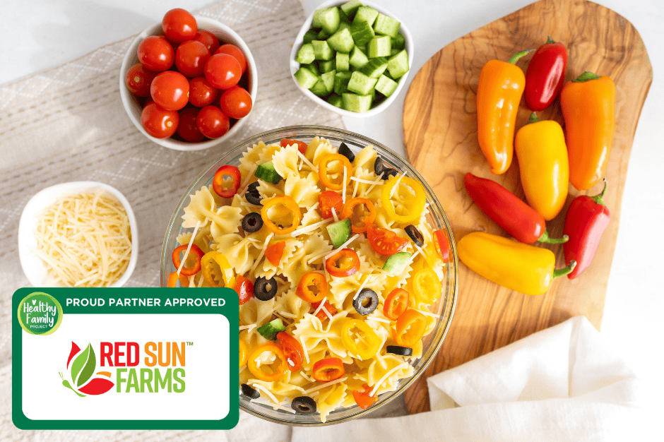 Rainbow Italian pasta salad with bowtie pasta, mini sweet peppers, cherry tomatoes, cucumbers, olives, and shredded cheese