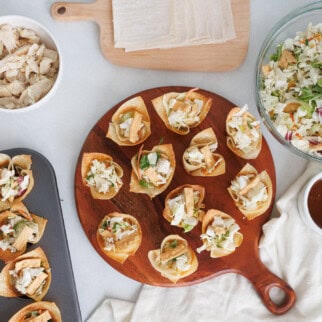 Easy chicken wonton cups with cabbage slaw and dipping sauce, baked crispy and served as a bite-sized appetizer